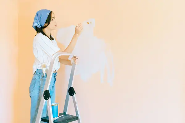 Interior painting in Oxnard: painter on a stepladder rolling a wall